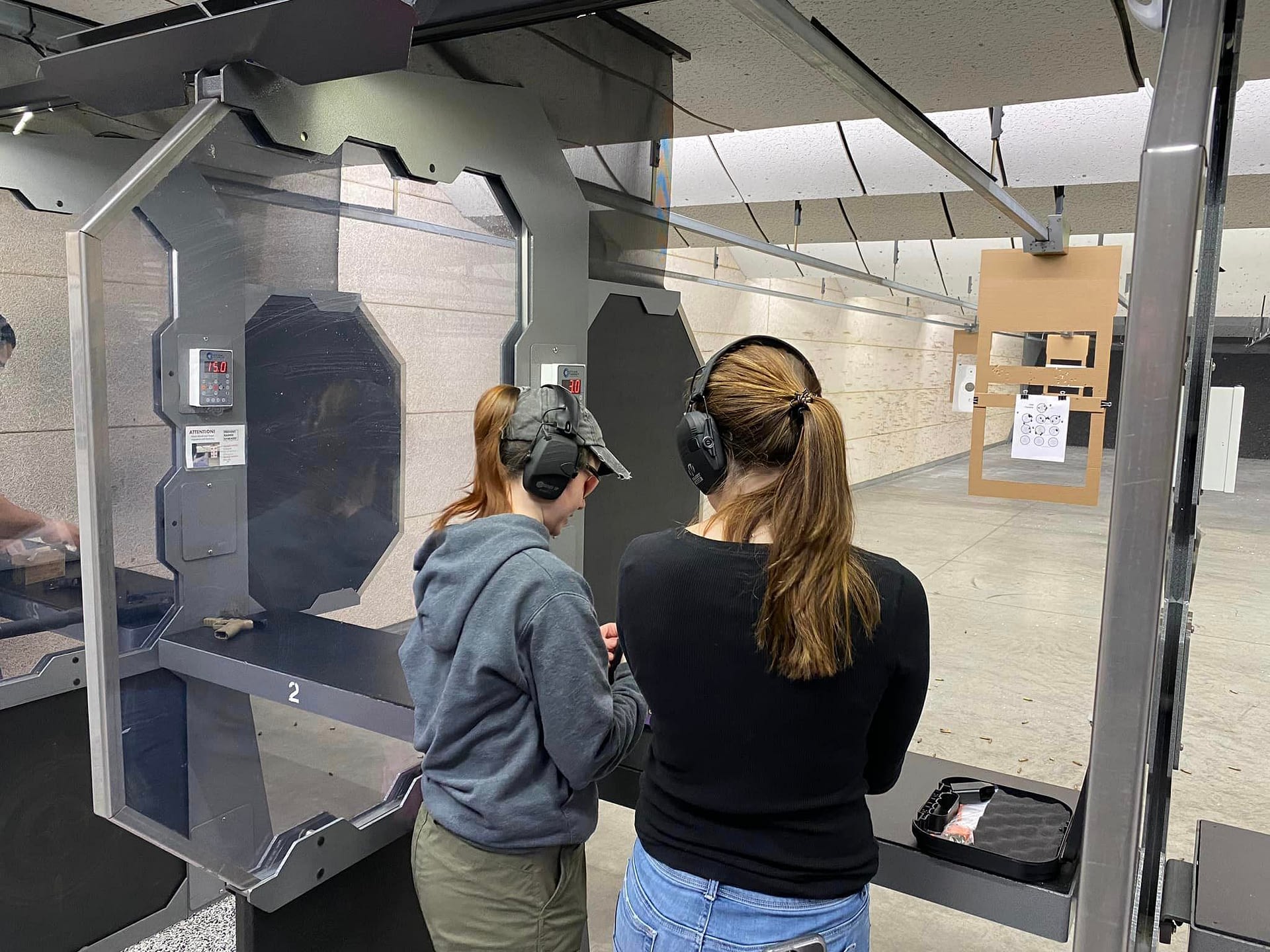 Intro To Handgun A Female instructor coaching a female student how to shoot the Dot Torture Drill