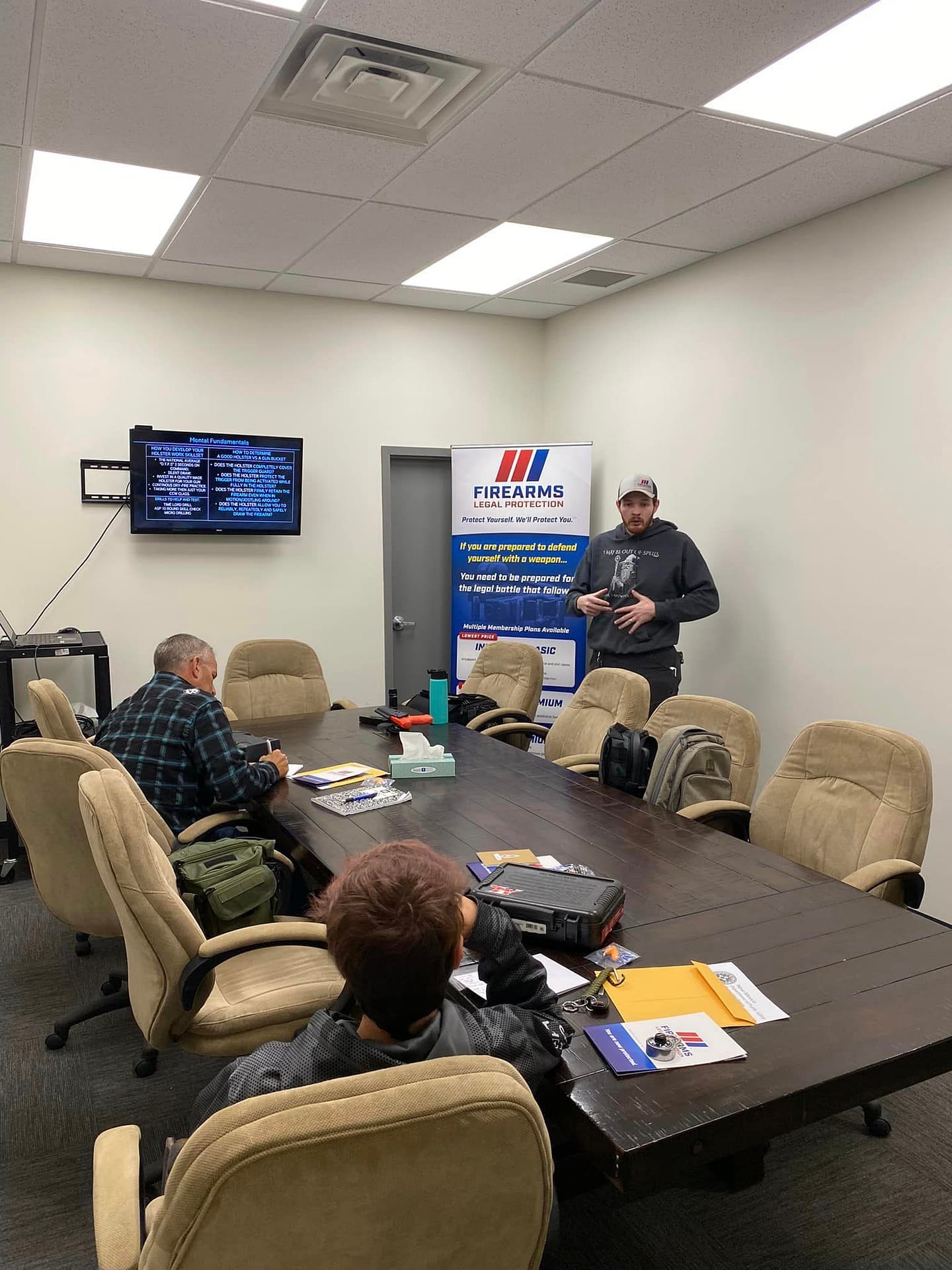 A Man in Guiding a Class of two people on Self defense Techniques